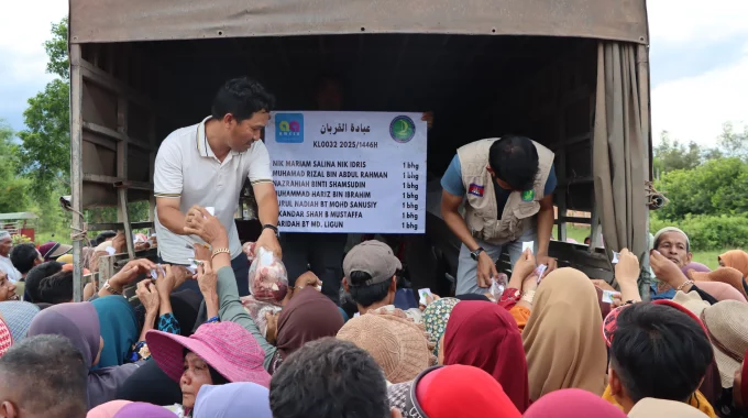 Petugas program ibadah korban sedang mengagihkan daging korban kepada penduduk di Kemboja.