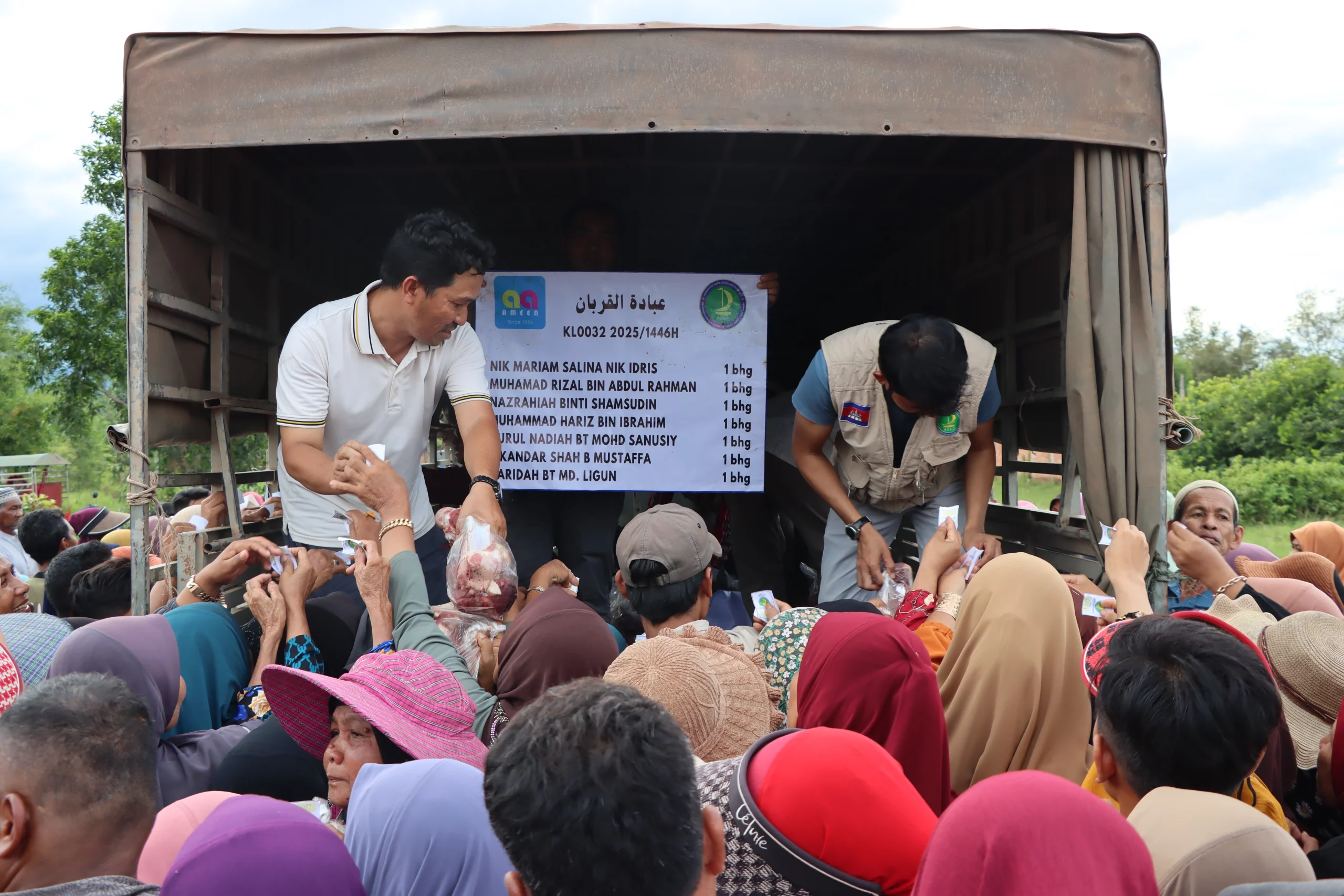 Petugas program ibadah korban sedang mengagihkan daging korban kepada penduduk di Kemboja.